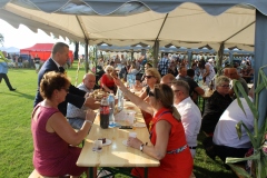 Starosta częstuje mieszkanców chlebem dożynkowym