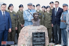 Współne zdjęcie pod obeliskiem z tablica pamiątkową i popiersiem.